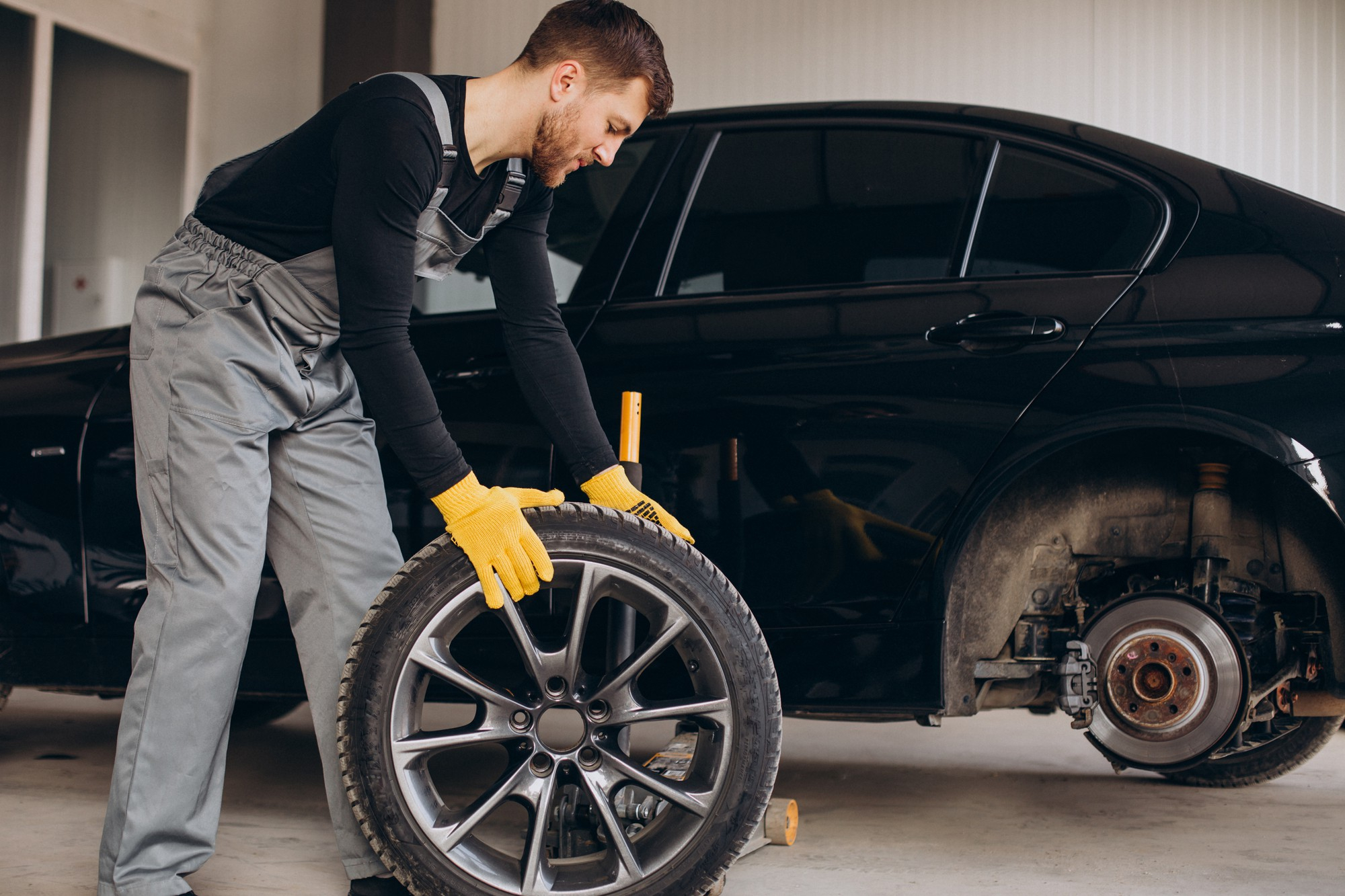 Mechanic rolling the tire away for repairs